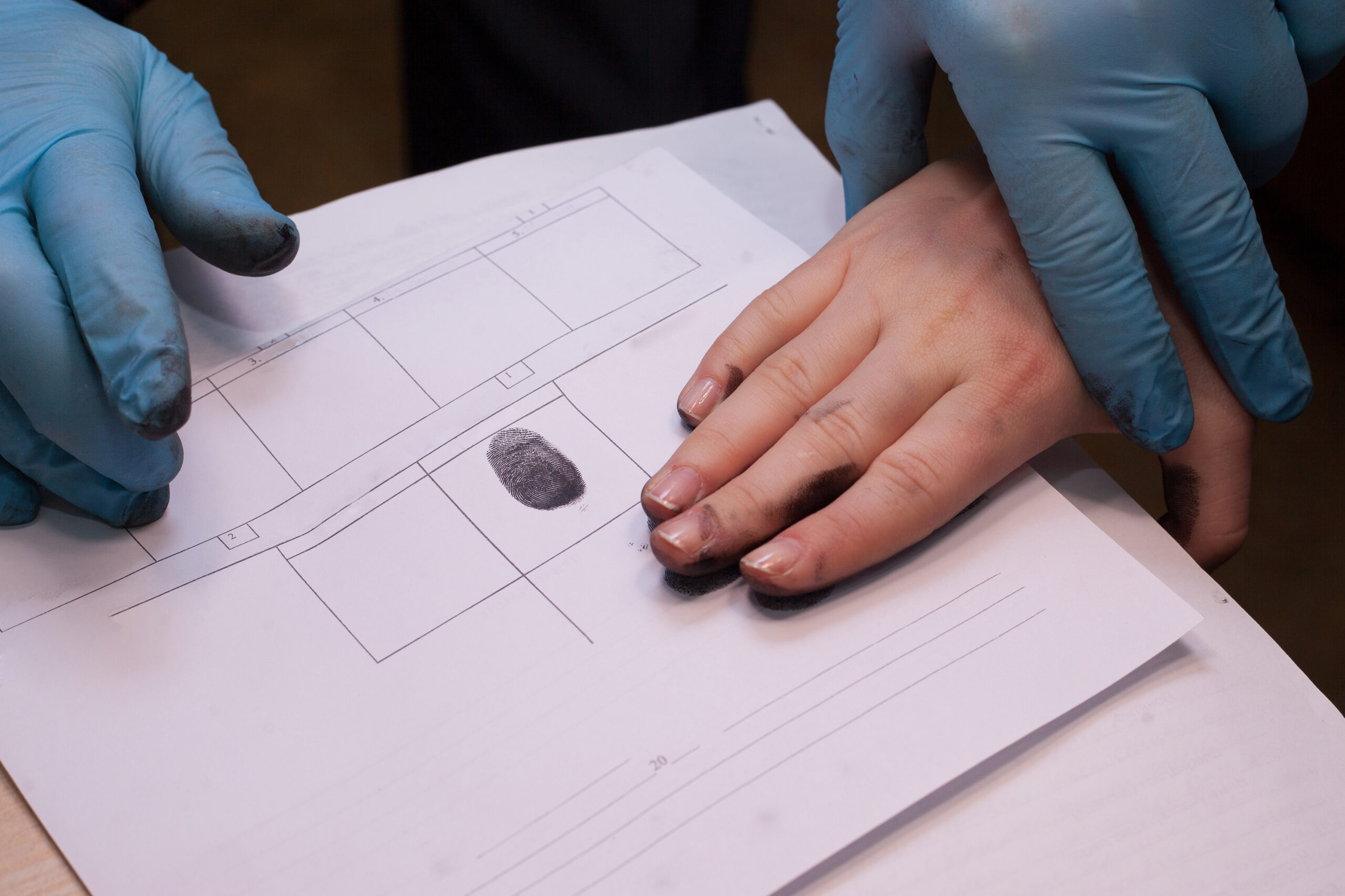 Crime investigation. expert takes fingerprints of a suspect in a crime.