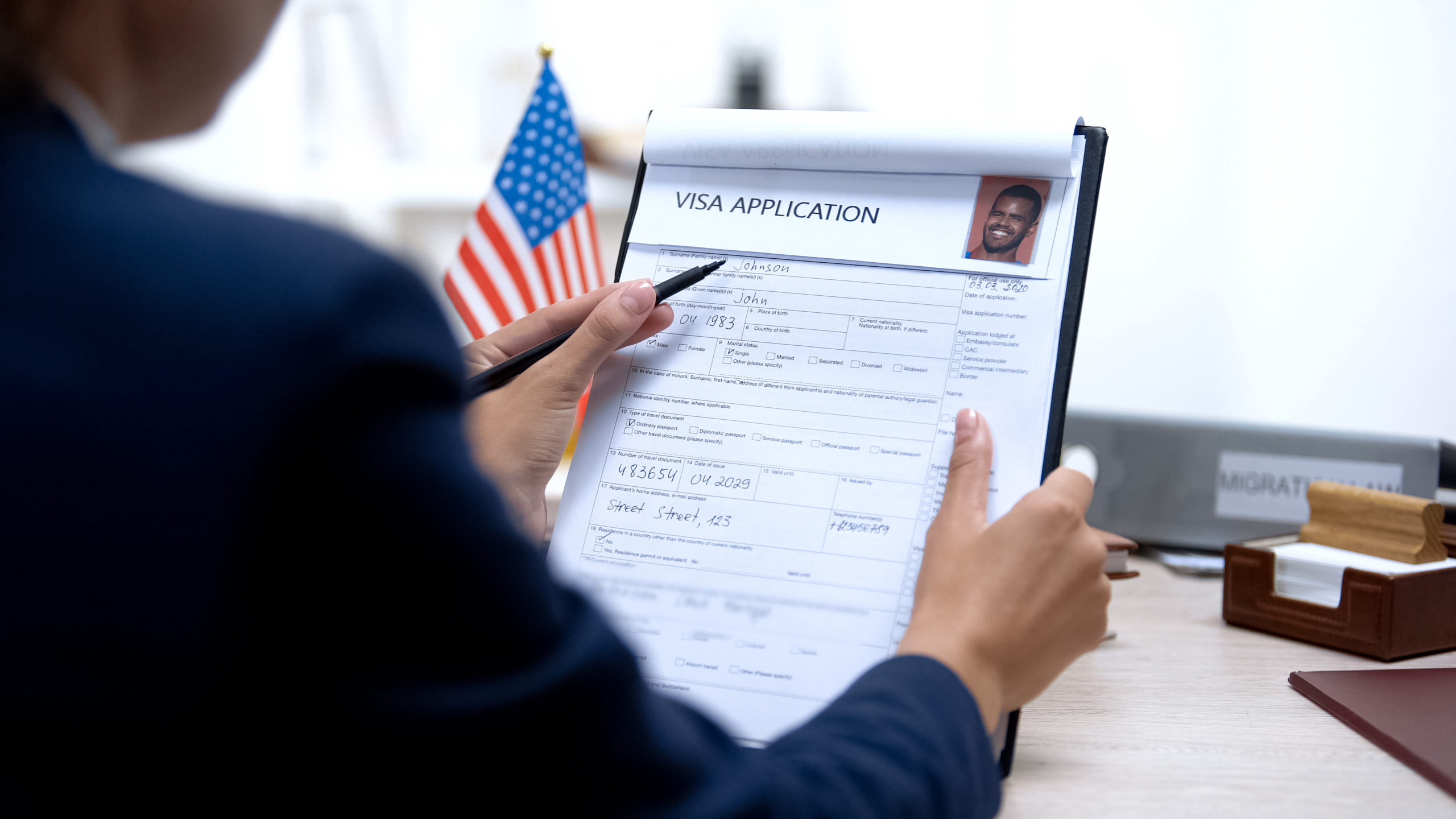 Consul worker checking visa application office, american flag, m