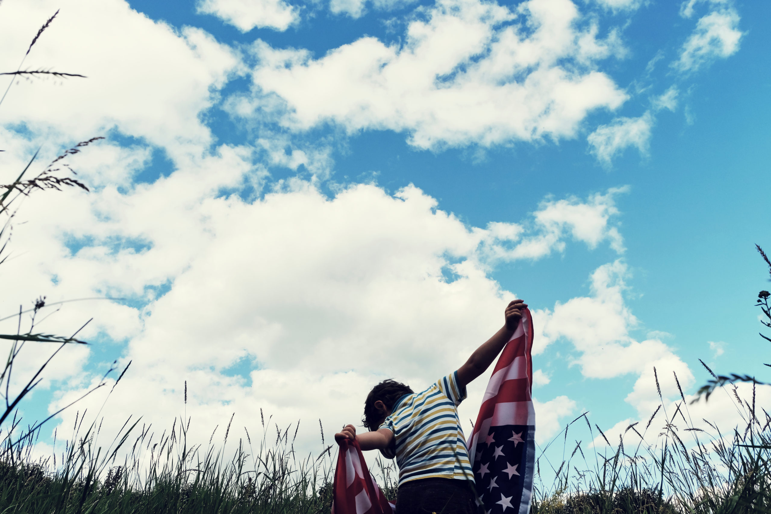 Patriotic holiday.Young boy with American flag.USA celebrate 4th of July.