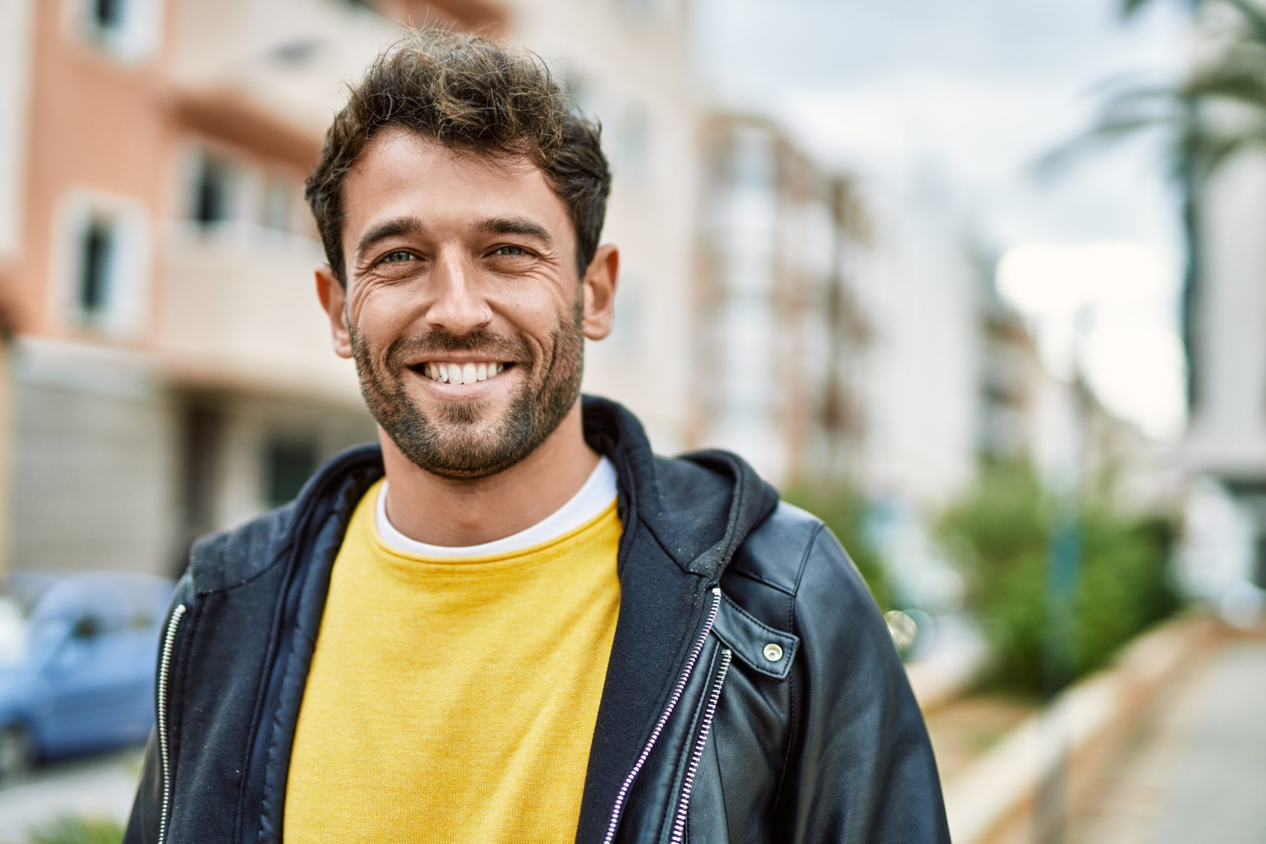 Handsome hispanic man with beard smiling happy outdoors