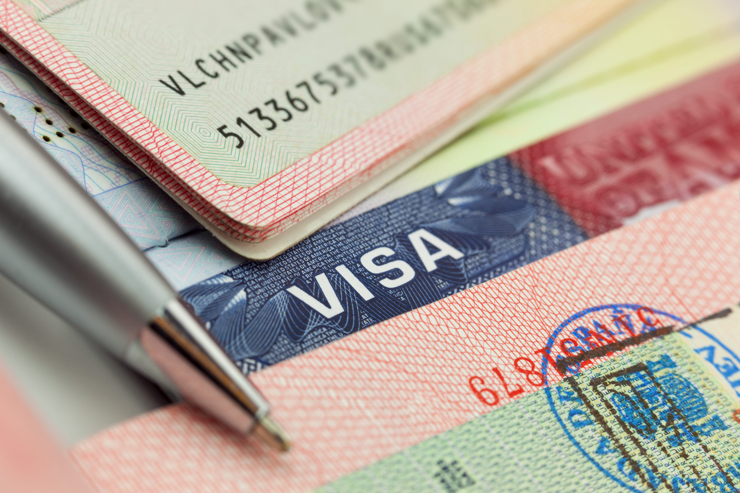 Different visas and stamps in a passport travel background